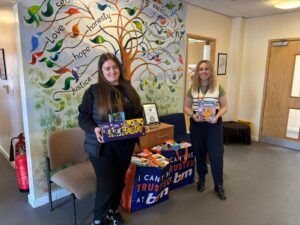Tank Consult donating Easter eggs to a school with staff at an outreach table.